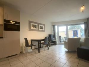 a kitchen and living room with a table and chairs at Meidoornstraat 2 parterre in Cadzand