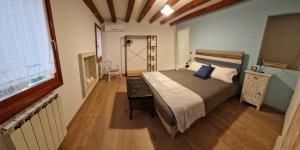 een slaapkamer met een groot bed en een houten vloer bij Cà Wanda in Chioggia