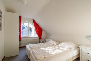 1 dormitorio con 2 camas y ventana en Villapark Kamperfoelie 77, en De Koog