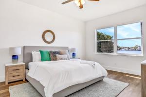 a white bedroom with a large bed and a window at Indian Rocks Beach Hideaway in Clearwater Beach