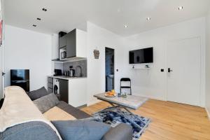 salon z kanapą i stołem w obiekcie Appartement - Stade de France w mieście Saint-Denis
