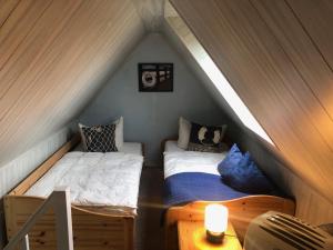 Pruchtenにあるromantisches Ferienhaus Boddenblick mit Saunaのベッドルーム(ベッド2台付)が備わる屋根裏部屋です。