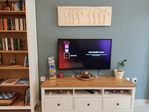 a tv sitting on top of a dresser in a room at Central & Comfortable, 70m² Apt in Neos Kosmos in Athens