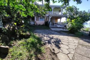 a house with a stone walkway in front of it at Bungalow with sea view in Deshaies in Deshaies +1 photo