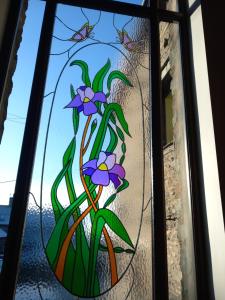 ケンダルにあるHayfellside Nookの紫色の花の植物を用いたステンドグラス窓