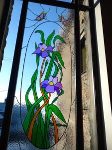 a stained glass window with a plant with purple flowers at Hayfellside Nook in Kendal