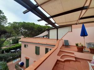 a balcony with a pink railing and a blue umbrella at Bilo La Pérgola in Procchio