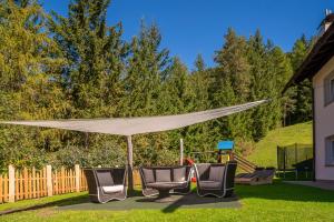 a group of chairs under a canopy in a yard at Residence Prapoz in Ortisei