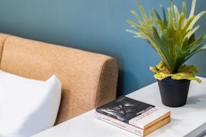 un libro y una planta en una mesa junto a una cama en Lin Suites by Olala Homes en Taipéi