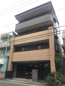 東京的住宿－Oku Apartment，停在前面的一座带摩托车的建筑