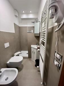 ein Badezimmer mit weißer Toilette und Waschbecken in der Unterkunft Rainbow Hotel Depandance Joli in San Marino + 31 Fotos