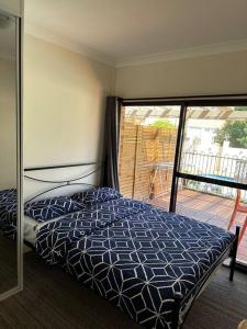 ein Schlafzimmer mit einem Bett und einem Balkon in der Unterkunft 2 bedroom retreat with Swimming Pool in Baulkham Hills