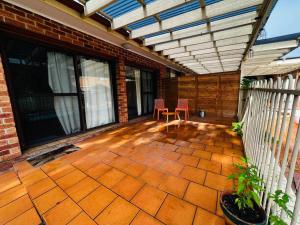 een patio met 2 stoelen en een luifel op een huis bij 2 bedroom retreat with Swimming Pool in Baulkham Hills