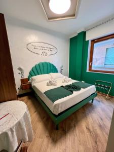 ein Schlafzimmer mit einem Bett mit grünem Kopfteil in der Unterkunft Rainbow Hotel Depandance Joli in San Marino