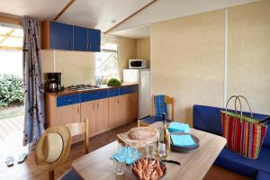 a kitchen and dining room with a table with food on it at Camping Park Er Lann in Saint-Pierre-Quiberon