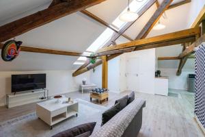 a living room with a couch and a tv at The Backstage in La Roche-en-Ardenne