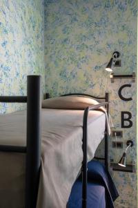 a bedroom with a bed with blue floral wallpaper at Ostello San Filippo Neri in Modena