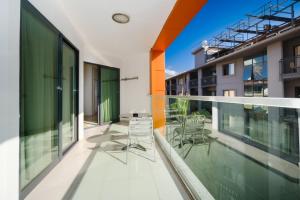 an apartment balcony with chairs and glass walls at Delfino Apart Hotel in Alanya