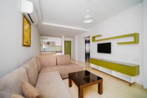 a living room with a couch and a tv at Delfino Apart Hotel in Alanya