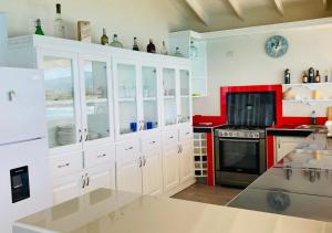 a kitchen with white cabinets and a stove top oven at Villa Daniela in Punta Rucia