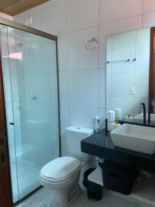 a bathroom with a toilet and a sink and a shower at ChaleVille - Chalé 4902 in Luis Correia