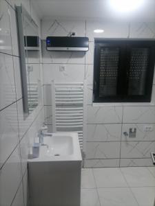 a white bathroom with a sink and a mirror at Vila Vlajić 2022 in Gornje Pale +7 photos