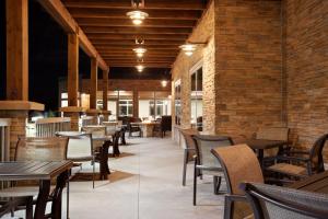 a restaurant with tables and chairs and brick walls at Country Inn & Suites by Radisson Roseville - St Paul in Roseville