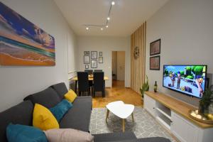 ein Wohnzimmer mit einem Sofa und einem Flachbild-TV in der Unterkunft Sporades Apartment in Volos