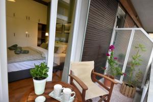 a small balcony with a table and a bedroom at Sporades Apartment in Volos