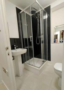 a bathroom with a shower and a toilet and a sink at Impeccable 2-Bed House in London
