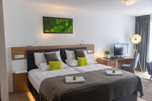 ein Schlafzimmer mit einem großen Bett mit zwei Handtüchern darauf in der Unterkunft Boardinghouse HOME - adults only - in Konstanz