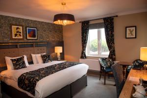 a hotel room with a bed and a desk and a window at The Red Lion Inn by Chef & Brewer Collection in Todwick