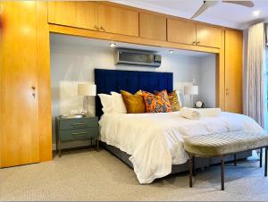 a bedroom with a large bed with a blue headboard at The Windsor- Hartbeespoort Dam in Hartbeespoort