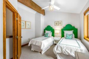 two beds in a room with green headboards at 2 Bed 2 Bath Apartment in Avon in Avon