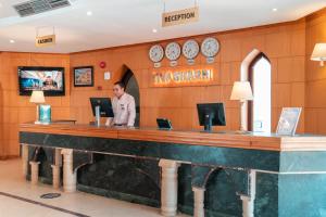 a man standing at a counter in a hotel lobby at Viva Sharm in Sharm El Sheikh