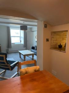 a living room with a table and a couch at Brook Cottage in Holmfirth