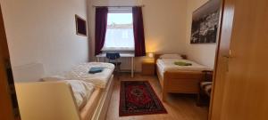 a small room with two beds and a window at 3 Schlafzimmer &Wohnküche in Oberhausen