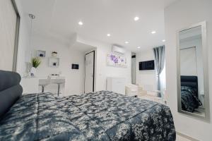 ein weißes Schlafzimmer mit einem Bett und einem Schreibtisch in der Unterkunft Gandrè Room in Mesagne