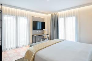 ein Hotelzimmer mit einem Bett und einem Flachbild-TV in der Unterkunft Boutique Hotel Luna Granada Centro in Granada
