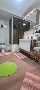 Un baño con una alfombra verde y un espejo grande. en 3 Schlafzimmer &Wohnküche, en Oberhausen