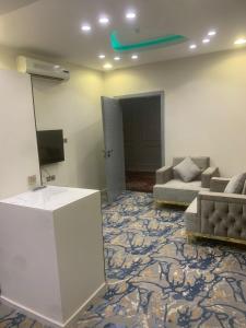 - un salon avec un canapé et une télévision dans l'établissement Orchida Turaif Hotel 1, à Turaif