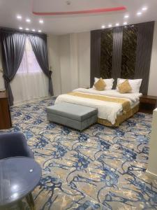 a bedroom with a large bed and a large carpet at Orchida Turaif Hotel 1 in Ţurayf