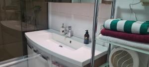 a bathroom with a sink and a shower and towels at 3 Schlafzimmer &Wohnküche in Oberhausen
