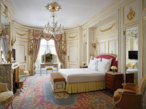 a bedroom with a king sized bed and a chandelier at The Ritz London in London +37 photos