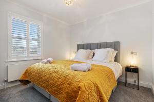 a bedroom with a large bed with a yellow blanket at Cottage Mews - Seaside Cottage Parking Terrace in Tenby