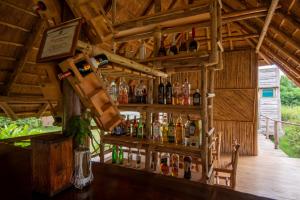 eine Bar in einer Holzhütte mit Alkoholflaschen in der Unterkunft NKUNDWA NILE VIEW LODGE in Wanseko