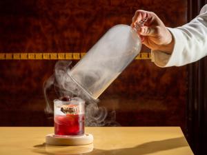 a person pouring a potion into a glass jar at The Ritz London in London