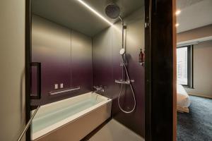 a bathroom with a bath tub and a shower at The Royal Park Canvas Ginza Corridor in Tokyo