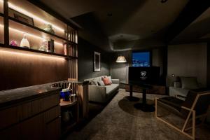 a living room with a couch and a television at The Royal Park Canvas Ginza Corridor in Tokyo