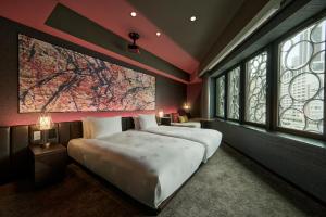 a bedroom with two beds and a large window at The Royal Park Canvas Ginza Corridor in Tokyo